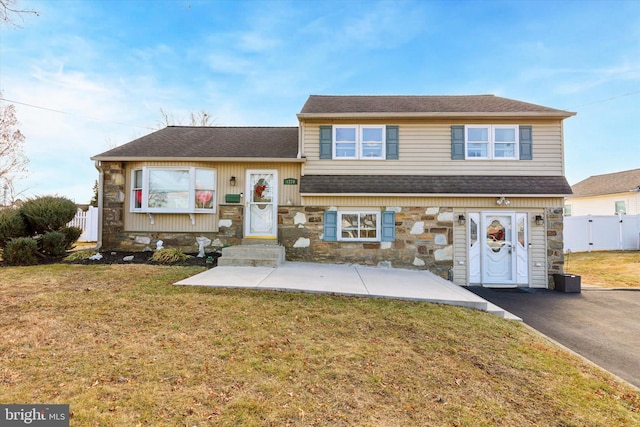 tri-level home with a front yard and a patio