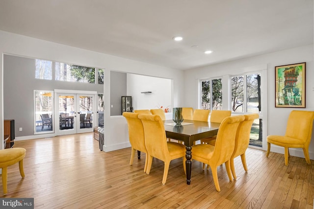 dining space with light hardwood / wood-style floors and french doors