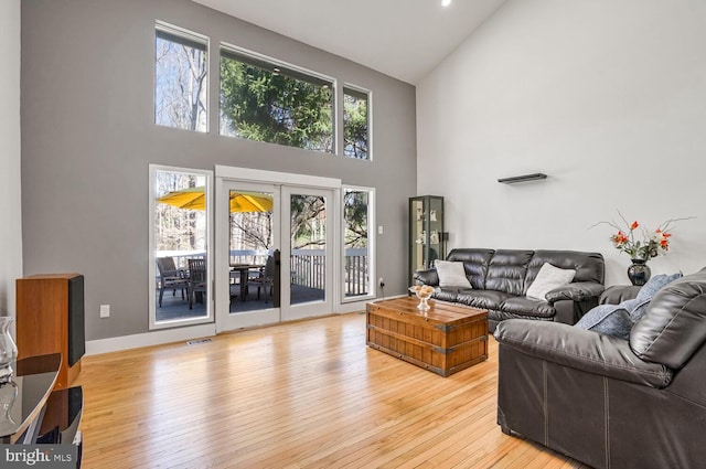 living room with french doors, a healthy amount of sunlight, and light wood-type flooring