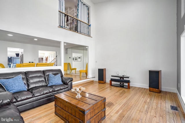 living room featuring a towering ceiling and wood-type flooring