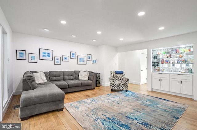 living room featuring bar area and light hardwood / wood-style flooring