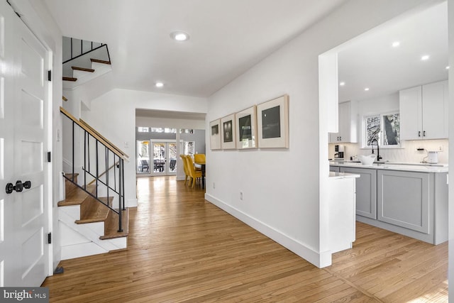 foyer entrance with plenty of natural light, sink, and light wood-type flooring