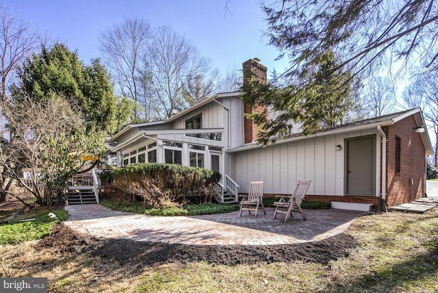 rear view of property featuring a sunroom and a patio area