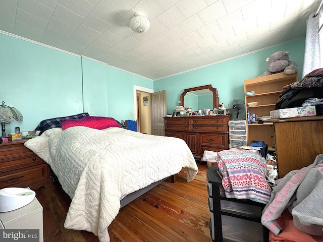 bedroom with crown molding and dark hardwood / wood-style floors