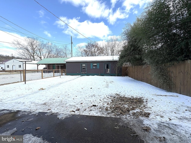 view of snow covered rear of property