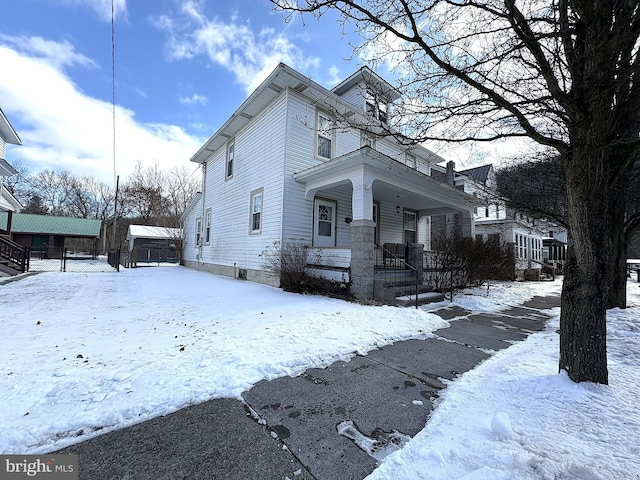 view of snow covered exterior with covered porch