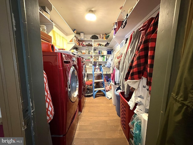 laundry area with light hardwood / wood-style floors and washer and dryer