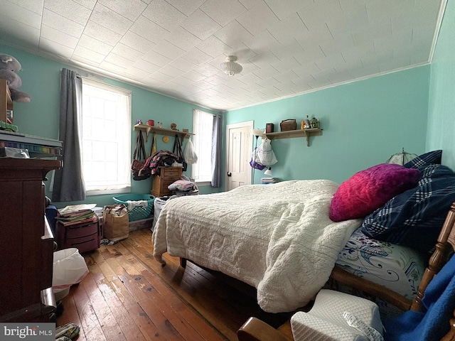 bedroom with wood-type flooring and ornamental molding