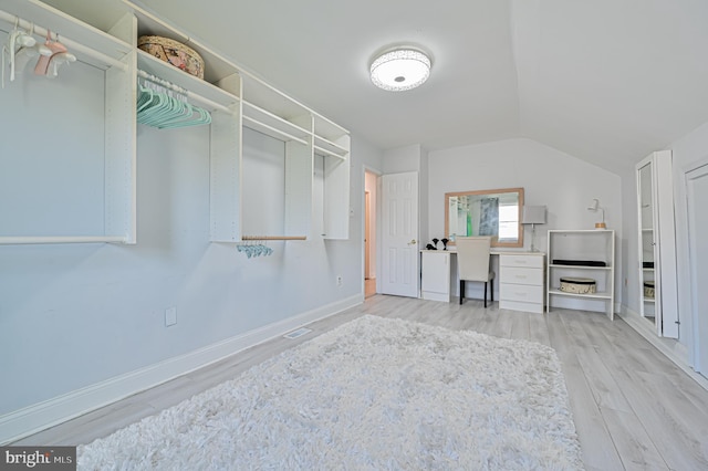 spacious closet with lofted ceiling and hardwood / wood-style floors