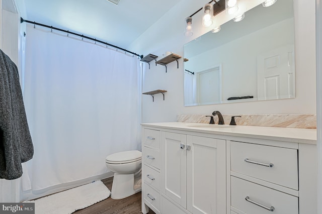 bathroom with vanity, toilet, and hardwood / wood-style floors