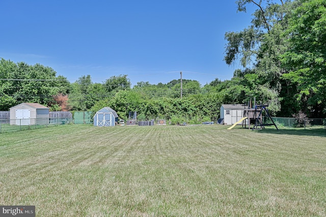 view of yard featuring a playground and a storage unit