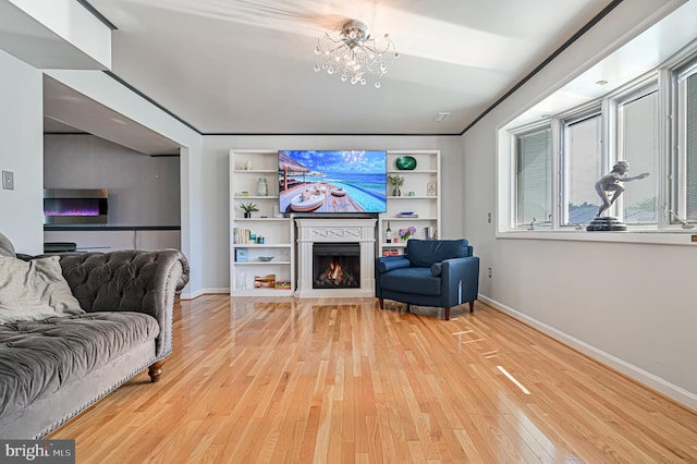 living room with hardwood / wood-style flooring, a chandelier, and built in shelves