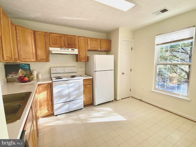 kitchen with sink, white appliances, and a textured ceiling