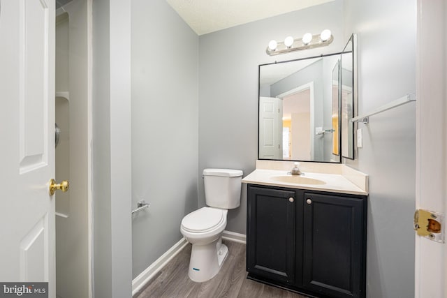 bathroom with hardwood / wood-style flooring, vanity, and toilet