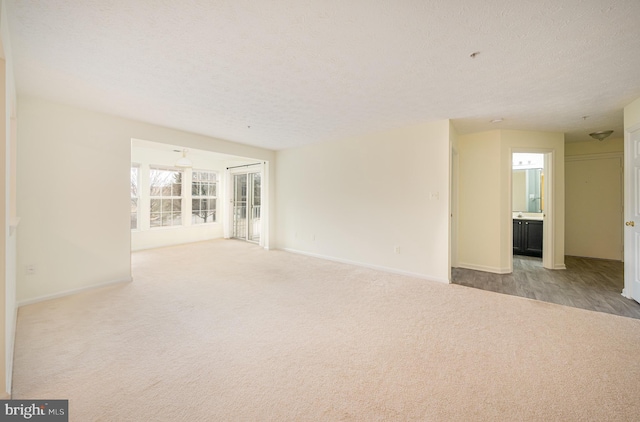 carpeted spare room featuring a textured ceiling