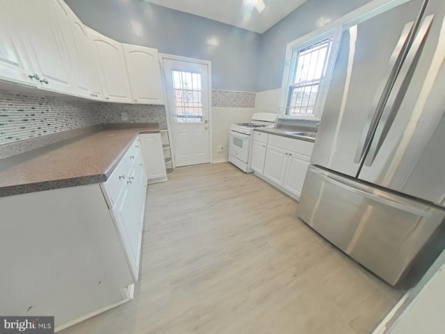 kitchen featuring white cabinetry, white gas stove, stainless steel fridge, and light wood-type flooring