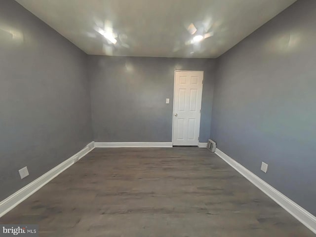 spare room featuring dark wood-type flooring