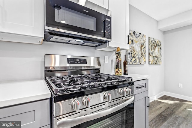 kitchen featuring stainless steel appliances, dark wood-type flooring, and white cabinets