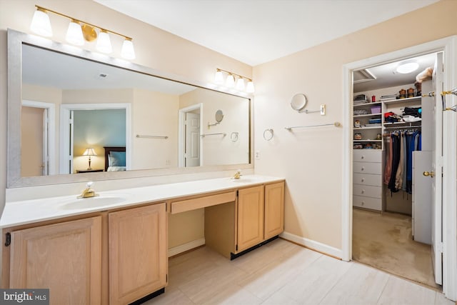 full bathroom with a sink, double vanity, and a walk in closet