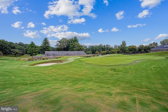 surrounding community featuring view of golf course and a lawn