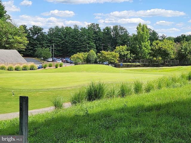 view of home's community featuring view of golf course and a lawn