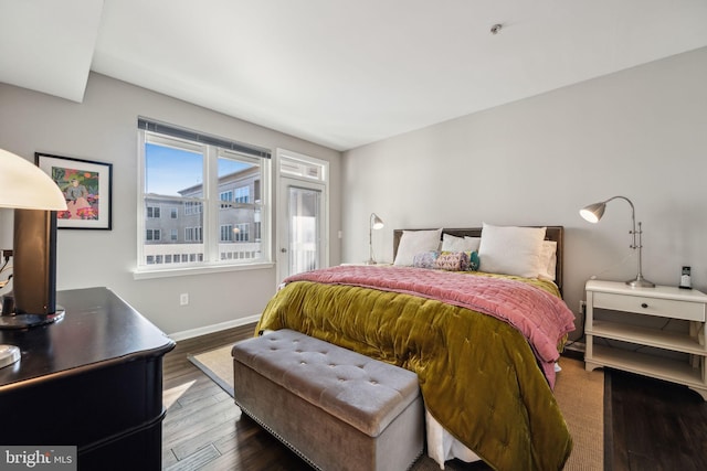 bedroom with baseboards, dark wood-type flooring, and access to exterior