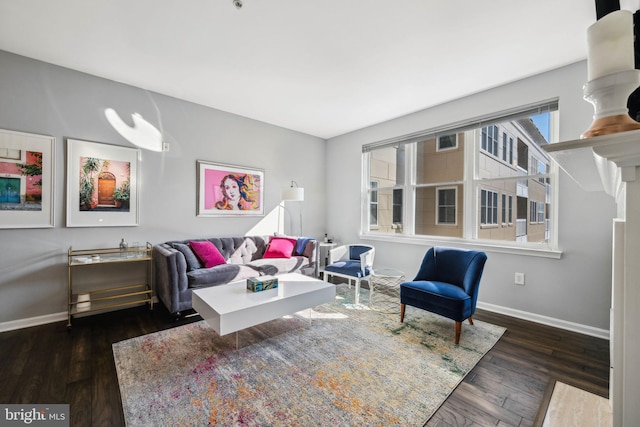 living area featuring dark wood-style flooring and baseboards