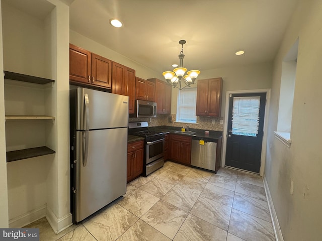 kitchen with sink, decorative light fixtures, a chandelier, stainless steel appliances, and decorative backsplash