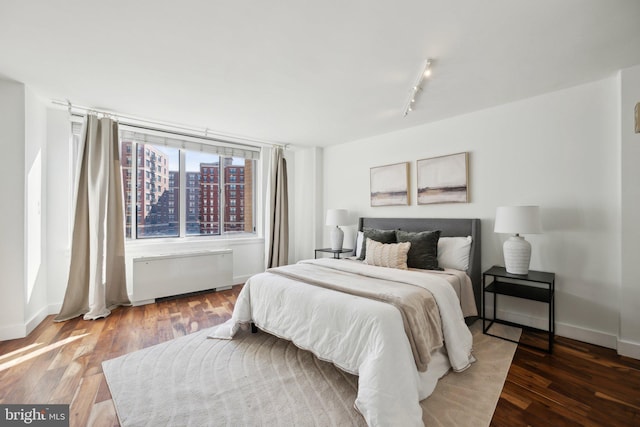 bedroom with wood-type flooring and track lighting