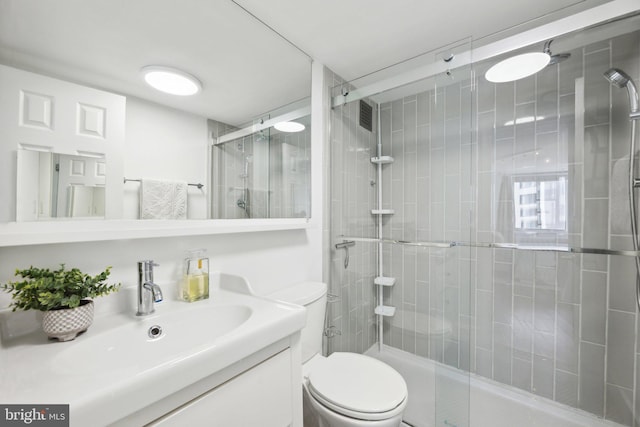 bathroom featuring vanity, walk in shower, and toilet