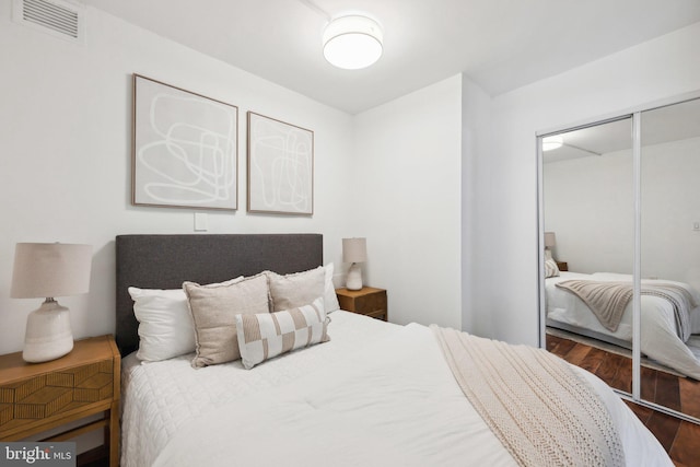 bedroom featuring dark wood-type flooring and a closet