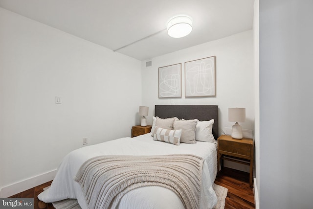 bedroom with dark wood-type flooring