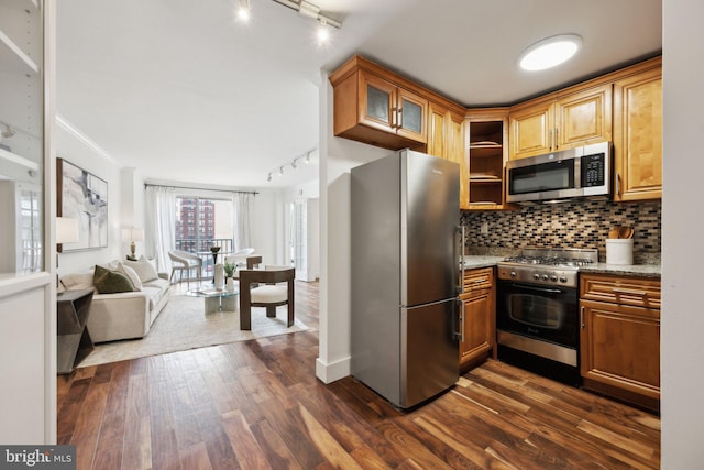 kitchen with light stone countertops, backsplash, stainless steel appliances, and dark hardwood / wood-style floors