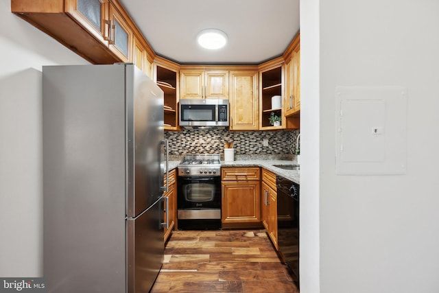 kitchen featuring dark wood-type flooring, appliances with stainless steel finishes, electric panel, light stone countertops, and decorative backsplash