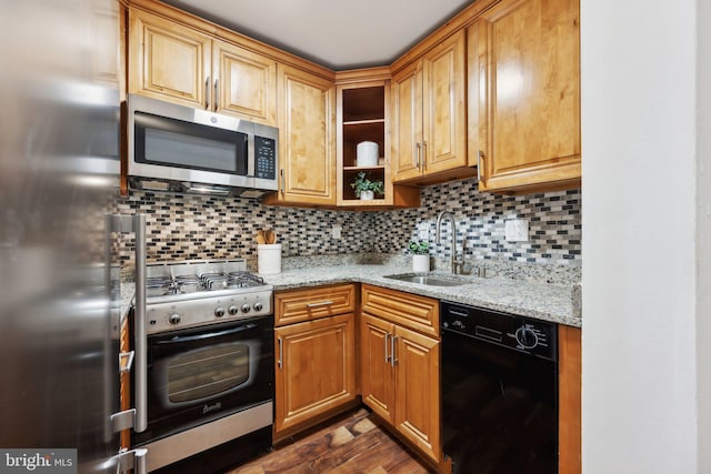 kitchen featuring sink, tasteful backsplash, appliances with stainless steel finishes, dark hardwood / wood-style flooring, and light stone countertops