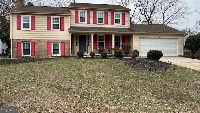 tri-level home featuring a garage, covered porch, and a front lawn