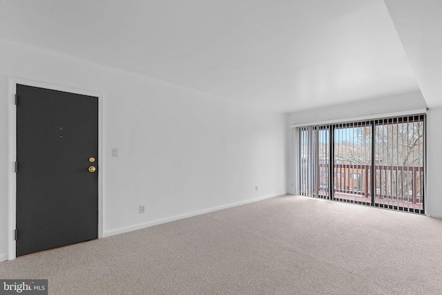 carpeted empty room featuring baseboards