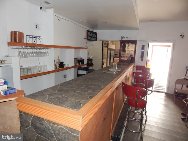 bar featuring dark wood-type flooring and tile countertops