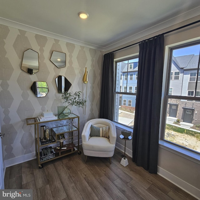 sitting room with ornamental molding and dark wood-type flooring