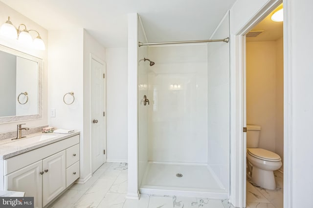 bathroom featuring walk in shower, vanity, and toilet