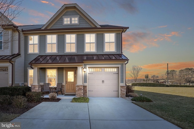 view of front of home featuring a yard, a garage, and covered porch