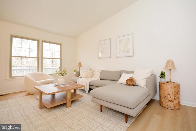 living room with lofted ceiling and light hardwood / wood-style flooring