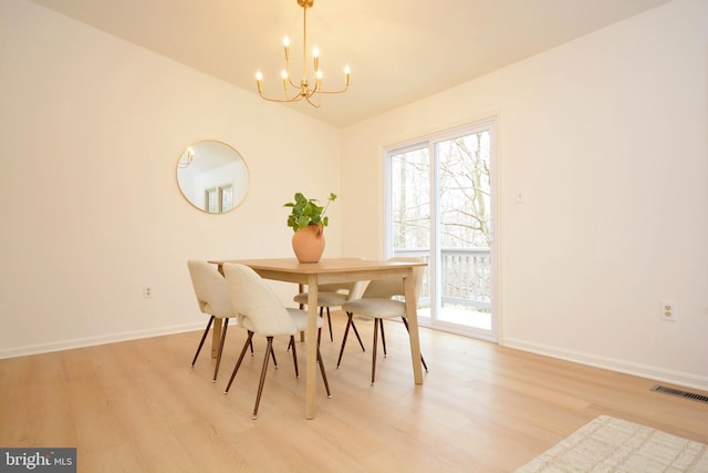 dining space featuring a chandelier, a wealth of natural light, and light wood-type flooring