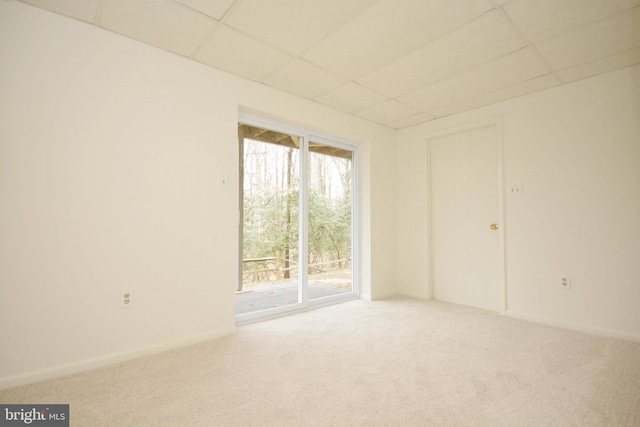 carpeted empty room featuring a paneled ceiling