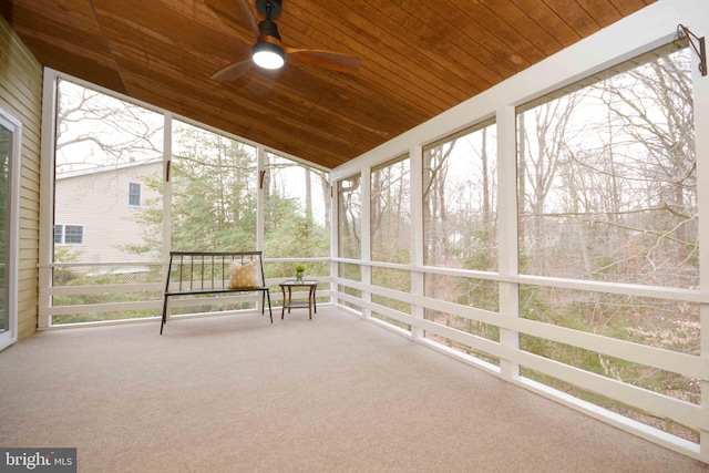 unfurnished sunroom featuring vaulted ceiling, wooden ceiling, and ceiling fan