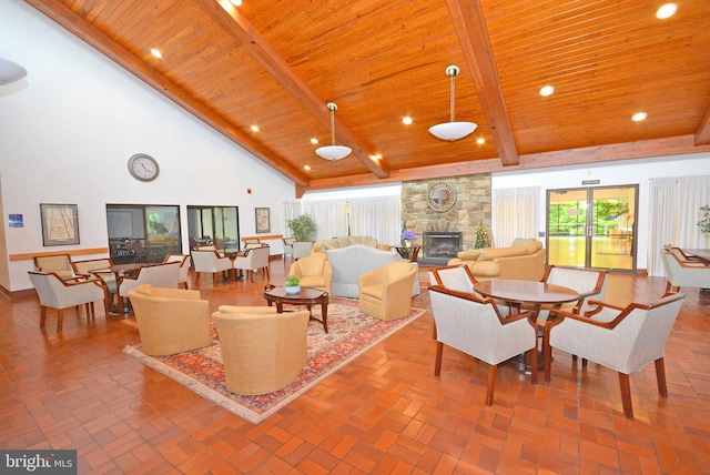 living room with a stone fireplace, high vaulted ceiling, beam ceiling, and wooden ceiling