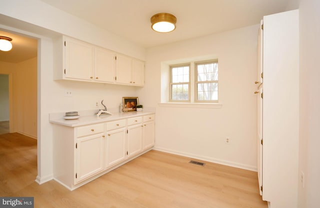 kitchen featuring light hardwood / wood-style floors and white cabinets