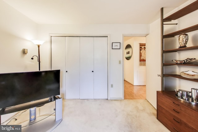 bedroom with light carpet and a closet