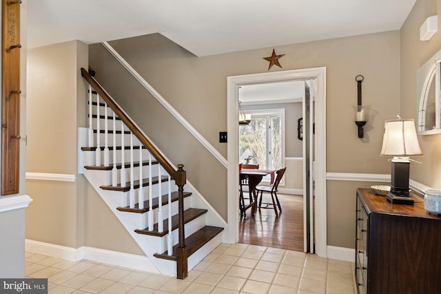 stairway featuring tile patterned flooring and baseboards