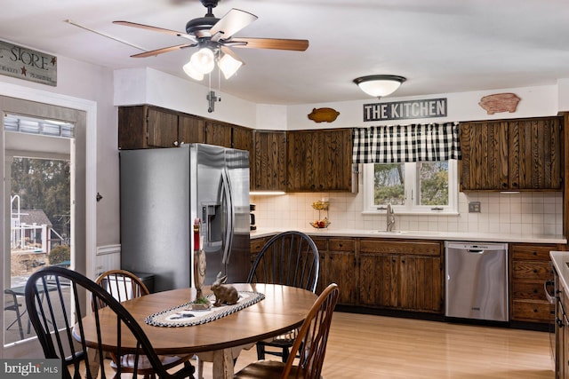 kitchen featuring tasteful backsplash, appliances with stainless steel finishes, light countertops, and dark brown cabinets